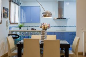 a dining room with blue cabinets and a table with chairs at Apartamento céntrico Candás in Candás +31 photos
