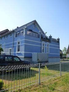 una casa azul con un coche aparcado delante de ella en Morizan, en Röbel