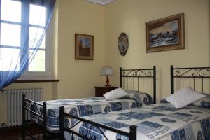 una camera da letto con due letti e una finestra di B&B Villa Cardellini a Savigliano