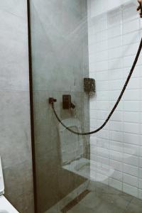 a shower with a glass door with a hose at Sol Hotel in Shkodër