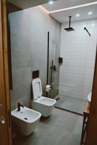 a bathroom with a white toilet and a sink at Sol Hotel in Shkodër