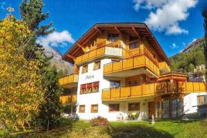 a large building with wooden balconies on a mountain at Haus Adora in Leukerbad