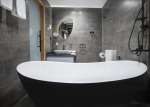 X Eastern Sidi Abdel Rahman Hotel في العلمين: حوض استحمام أبيض في حمام مع حوض
