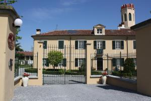 un grande edificio con un cancello di fronte di B&B Villa Cardellini a Savigliano