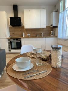 einen Holztisch mit Schalen und Platten in der Küche in der Unterkunft Appartement luxueux rénové avec balcon & garage in Troyes