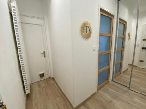 pasillo con puerta y espejo en Appartement luxueux rénové avec balcon & garage, en Troyes 2 fotos más