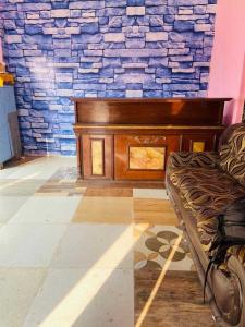un banco en una habitación con una pared de piedra en POP Radhe Oyo Hotel, en Manesar