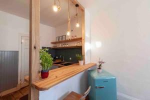 - une cuisine avec un comptoir et un réfrigérateur bleu dans l'établissement City Apartment, à Lübeck