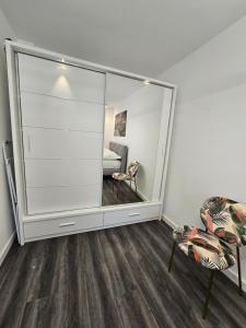 a mirror in a room with a chair and a bed at Galaxy Apartments 2 in Słupsk