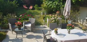 een patio met een tafel en stoelen en een parasol bij Le Vieux Tilleul in Vaires-sur-Marne