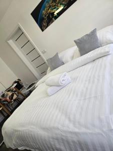 a white bed with two towels on top of it at Galaxy Apartments 2 in Słupsk