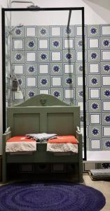 a bedroom with a bed and a wall with blue and white tiles at Koko & Baobab in Bordeaux