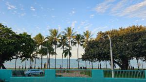 a car parked next to the beach with palm trees at Emthree Seaside Apartments in Townsville