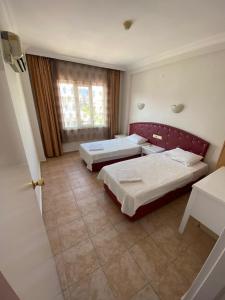a large room with two beds and a window at BASILS APART HOTEL in Marmaris