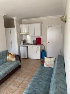 ein Wohnzimmer mit einem Sofa und einer Küche in der Unterkunft BASILS APART HOTEL in Marmaris