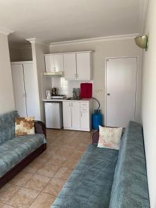 a living room with a couch and a kitchen at BASILS APART HOTEL in Marmaris