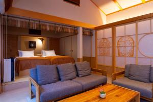 a living room with a bed and a couch and a table at Tsukiyominoza in Ise