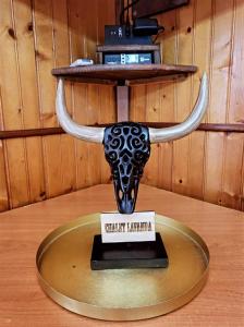 une statue d'un crâne de taureau avec des cornes sur une table dans l'établissement CHALET LAVANDA San Giacomo di roburent, à San Giacomo