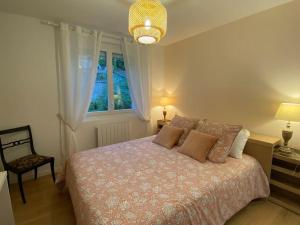 1 dormitorio con 1 cama, 1 silla y 1 ventana en Gite-le-7 en Brive-la-Gaillarde
