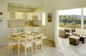 Una cocina y un comedor con mesa y sillas. en Villa Flora, en Oziás