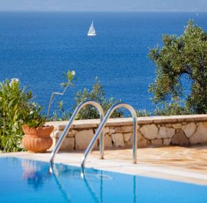 una piscina con un velero en el océano en Villa Flora, en Oziás