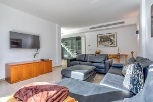 - un salon avec un canapé et une télévision dans l'établissement Villa LEsplendor, à Cala Sant Vicenç