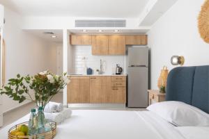 a kitchen with a table with a vase of flowers at דירת סטודיו מודרנית מול החוף By Edomlux in Eilat