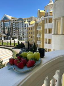 a plate of fruit on a ledge on a balcony at Синьо лято /Blue summer in Sunny Beach