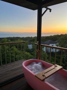 a bath tub sitting on a balcony with a view at Salty Breeze Bali in Ungasan