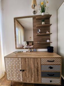 a bathroom with a wooden vanity with a mirror at Синьо лято /Blue summer in Sunny Beach