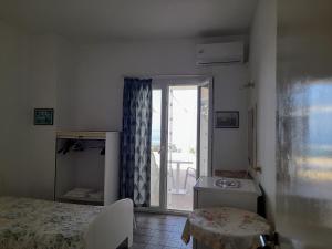 sypialnia z łóżkiem i drzwiami prowadzącymi na patio w obiekcie Varagoulis Giannis & Lenas Apartments w mieście Paramonas