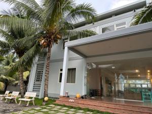 潘切P&T家庭度假村的一栋前面有棕榈树的房子