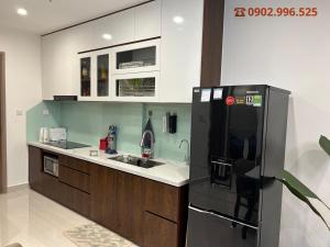 uma cozinha com um frigorífico preto e um lavatório em Luxury Apartment-Vinhomes Grand Park Quận 9-Bống Homestay em Long Bình