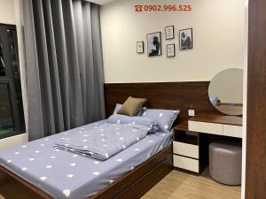 Long Bình的住宿－Luxury Apartment-Vinhomes Grand Park Quận 9-Bống Homestay，一间卧室配有一张带蓝色床单的床和一张书桌。