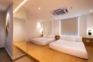 a bedroom with two beds and a window at The Bayou Hotel Langkawi in Pantai Cenang