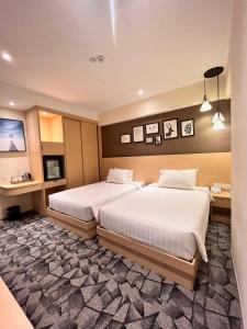 クアラルンプールにあるHotel Aman Kuala Lumpurのベッド2台とデスクが備わるホテルルームです。