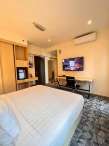 Habitación de hotel con cama blanca grande y escritorio. en Hotel Aman Kuala Lumpur en Kuala Lumpur