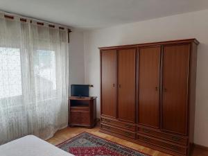 - une chambre avec une grande armoire en bois et une télévision dans l'établissement Ciasa de Bona, à Domegge di Cadore