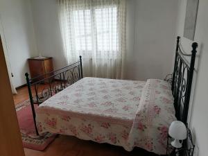 - une chambre avec un lit doté d'une couverture fleurie dans l'établissement Ciasa de Bona, à Domegge di Cadore