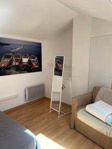 een slaapkamer met een bank en een schilderij aan de muur bij 9 - Agréable appartement, terrasse, vue mer et parking in Bandol