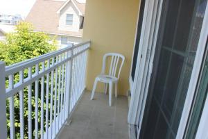 a white chair sitting on the balcony of a house at Champagne Island Apt in Luxembourg