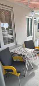 two chairs and a table with a cloth on a patio at Apartments Aleksandra in Crikvenica