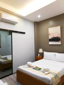 a bedroom with a large bed and a mirror at Dachannry's Place Hotel in Cagayan de Oro