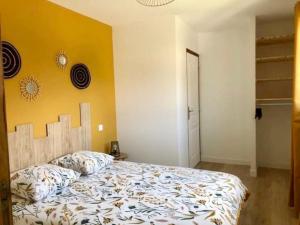um quarto com uma cama e uma parede amarela em Maison neuve à deux pas du Mont em Beauvoir