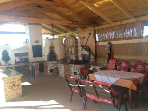 een eetkamer met een tafel en stoelen en een open haard bij Bíbic Vendégházak in Nagybajom