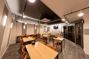 une salle à manger avec des tables et des chaises en bois dans l'établissement Ballantine Business Hotel, à Gwangju