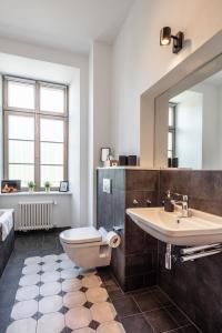 a bathroom with a sink and a toilet and a mirror at Acapella Suite Allegro 76qm I Altstadt l Weinberg in Heppenheim an der Bergstrasse