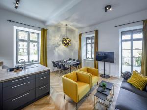 a kitchen and living room with a yellow chair and a couch at Acapella Suite Allegro 76qm I Altstadt l Weinberg in Heppenheim an der Bergstrasse