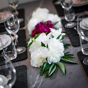 un tavolo con un mazzo di fiori bianchi e bicchieri di Acapella Suite Allegro 76qm I Altstadt l Weinberg a Heppenheim