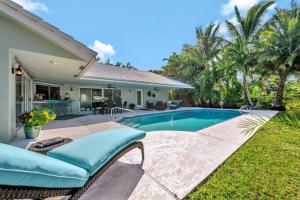 a backyard with a swimming pool and a house at Waterfront Oasis w/ Pool Minutes to Downtown! in Boynton Beach